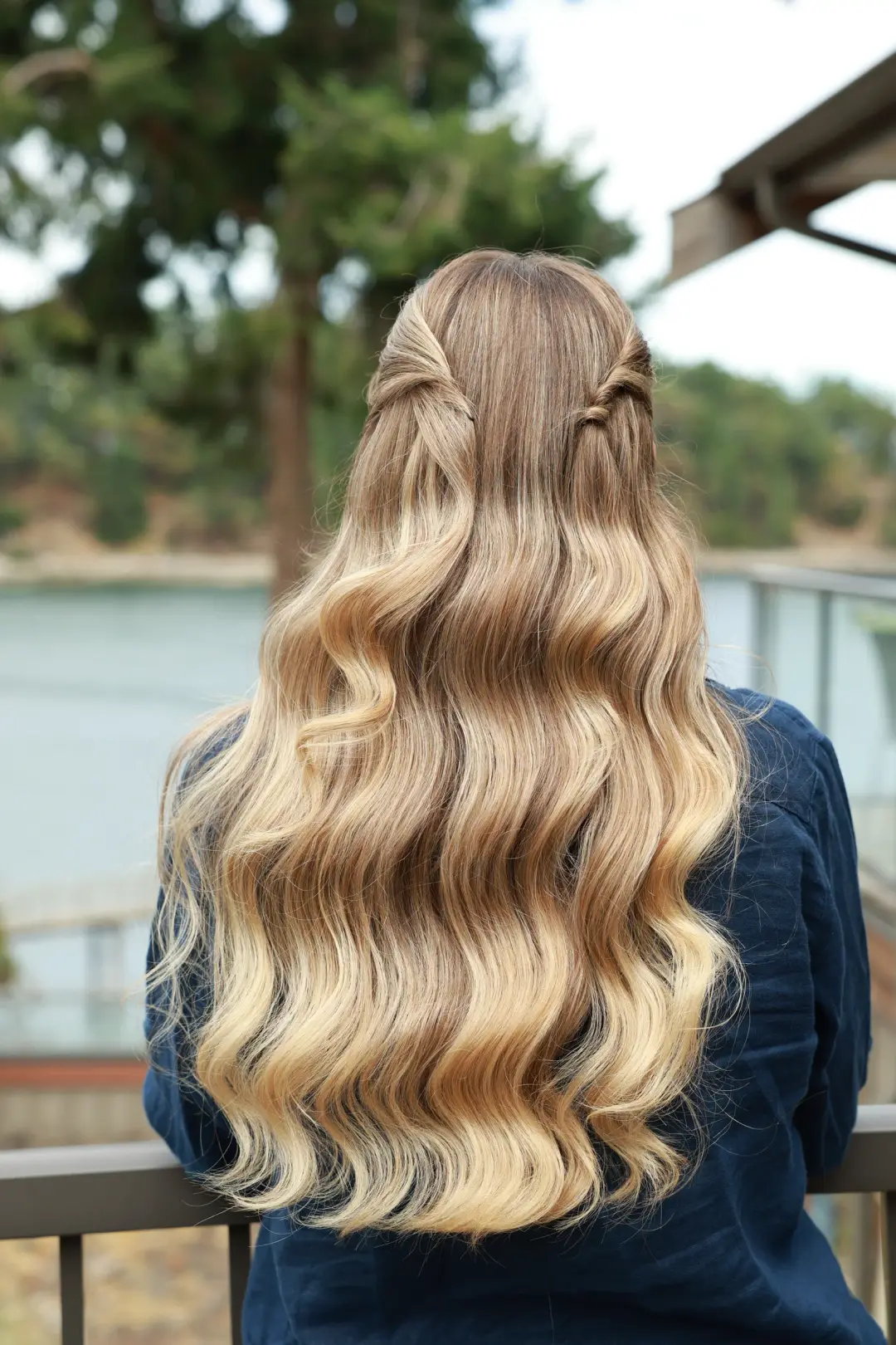 Long blonde Hollywood waves styled half-up with twisted sides